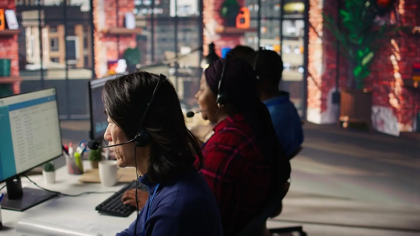 Крупный план опытного сотрудника, разговаривающего с клиентом через микрофон на наушниках.